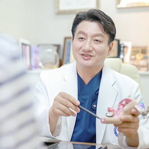 해부 모형을 들고 설명하며 웃는 대표원장
