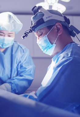 수술실에서 헤드라이트를 쓰고 집중하는 의료진