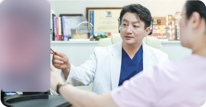 모니터의 내시경 영상(붉은 점막)을 가리키며 환자에게 설명하는 대표원장
